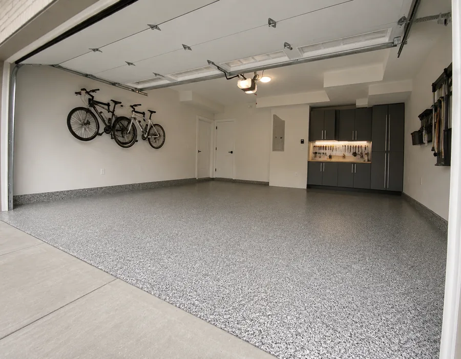 Decorative flake epoxy garage floor with storage cabinets and bicycles